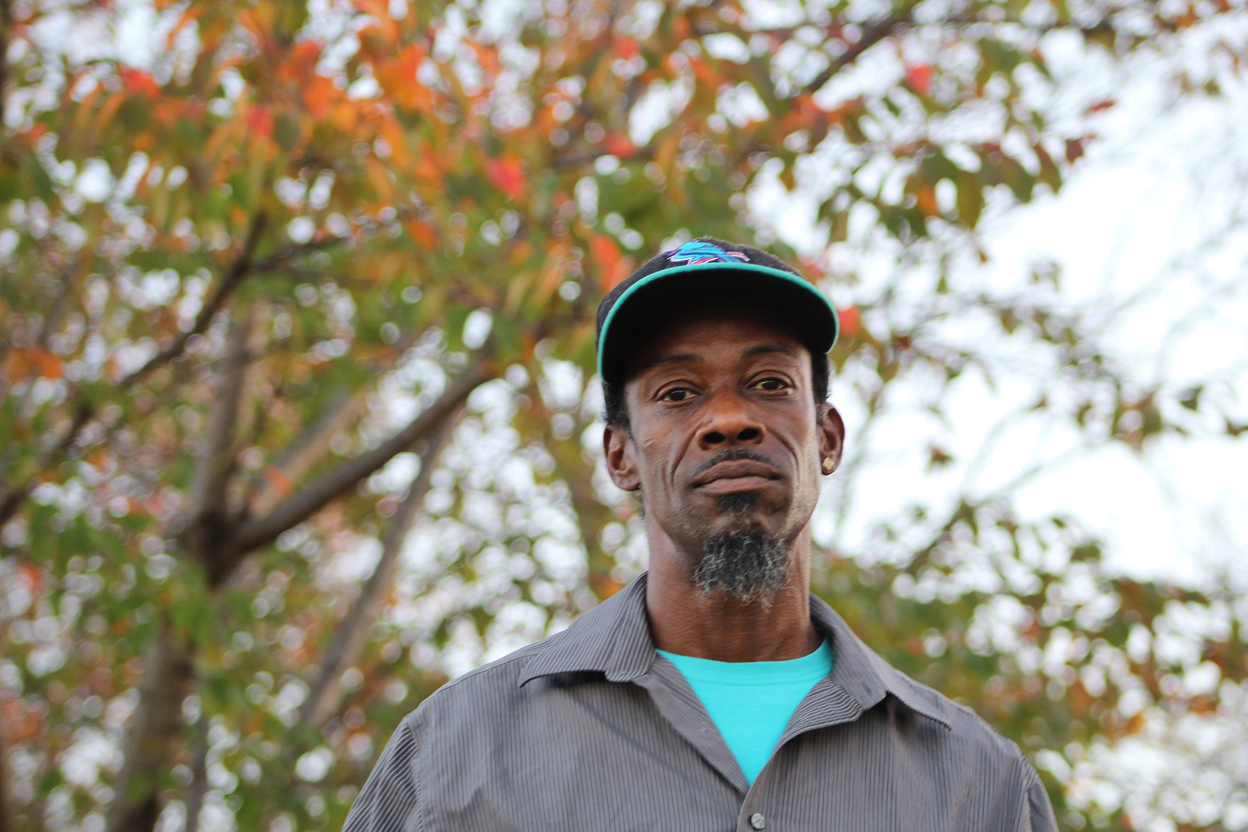 St. Louis client, Christopher, standing outside under trees