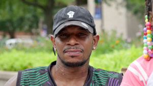 Bruce, a Louisville client, sitting outside in a baseball cap