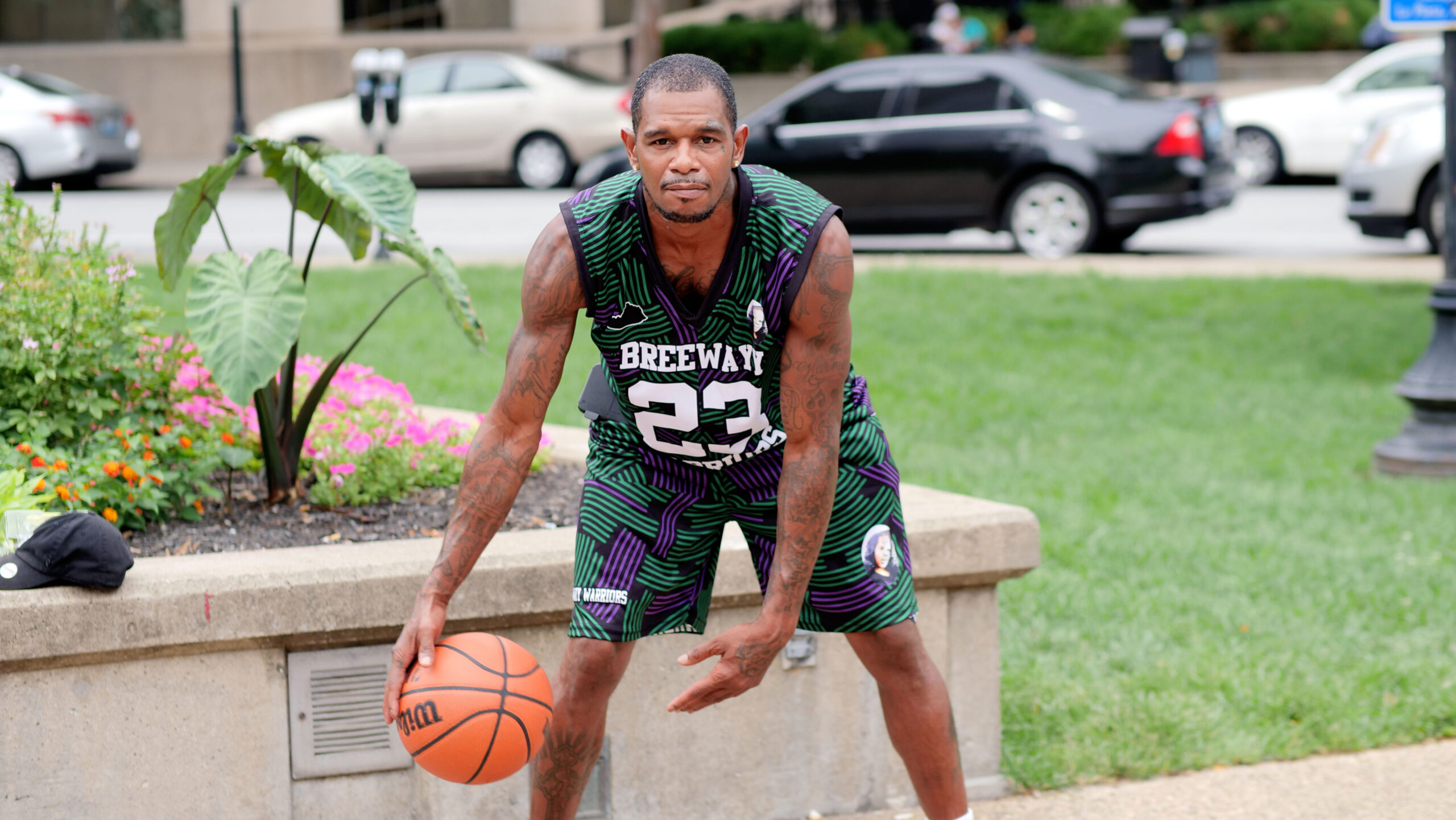 Bruce, a Louisville client, in a jersey, dribbling a basketball outside