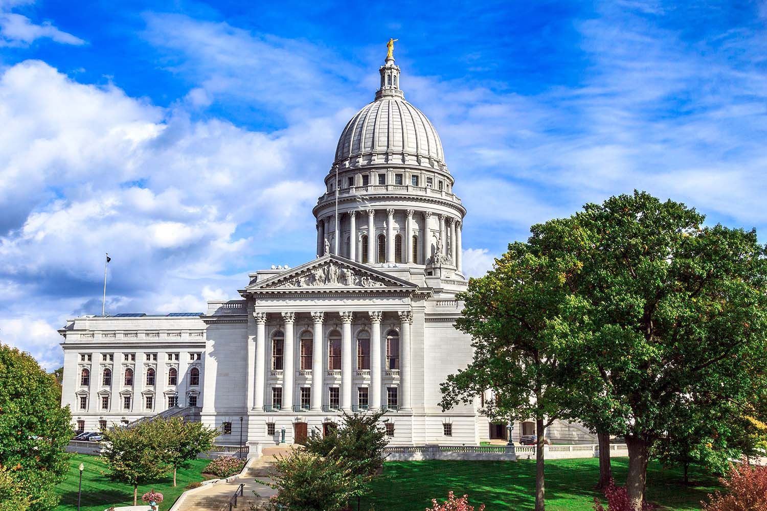 Madison Capitol Building, in the sunlight under a blue sky amongst green trees