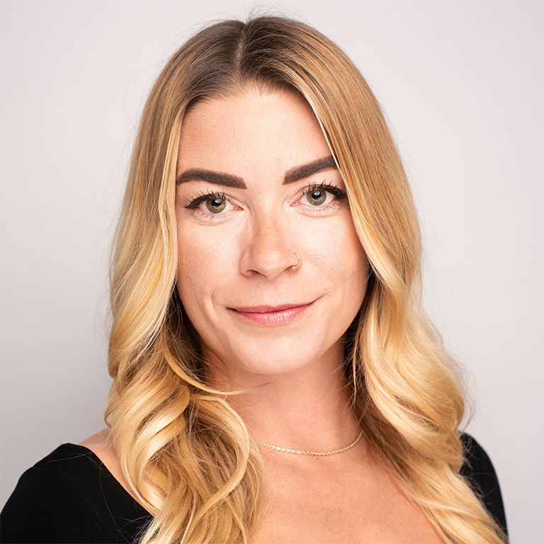 a woman with long blonde hair smiling into the camera; Erin George headshot